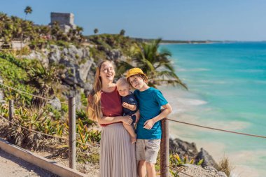 Anne ve iki oğul turist Pre-Columbian Maya duvarlı şehri Tulum, Quintana Roo, Meksika, Kuzey Amerika, Tulum, Meksika 'nın keyfini çıkarıyorlar. El Castillo - Şato Maya şehri Tulum ana tapınağı.