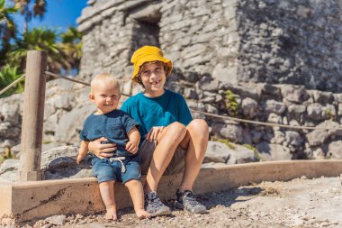 Kolombiya öncesi Maya şehri Tulum, Quintana Roo, Meksika, Kuzey Amerika, Tulum, Meksika manzarasının tadını çıkaran iki kardeş turist. El Castillo - Şato Maya şehri Tulum ana tapınağı.