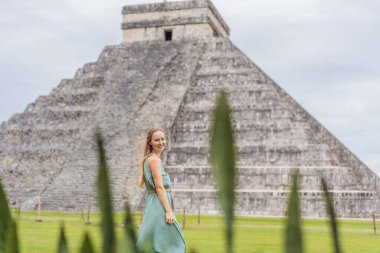 Chichen Itza olarak bilinen Maya mimarisinin eski piramidini ve tapınağını gözlemleyen güzel bir turist kadın. Bunlar eski Kolombiya öncesi medeniyetin kalıntıları.