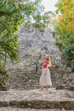 Coba, Meksika 'da kadın turist. Meksika 'daki antik Maya şehri. Coba arkeolojik bir alan ve Yucatan Yarımadası 'nın ünlü bir simgesidir. Meksika 'da bir piramidin üzerindeki bulutlu gökyüzü.