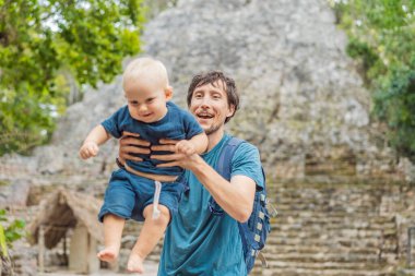 Baba ve oğul turistler Coba, Meksika 'da. Meksika 'daki antik Maya şehri. Coba arkeolojik bir alan ve Yucatan Yarımadası 'nın ünlü bir simgesidir. Meksika 'da bir piramidin üzerindeki bulutlu gökyüzü.