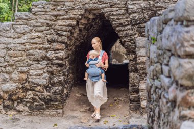 Anne ve oğul turistler Coba, Meksika 'da. Meksika 'daki antik Maya şehri. Coba arkeolojik bir alan ve Yucatan Yarımadası 'nın ünlü bir simgesidir. Meksika 'da bir piramidin üzerindeki bulutlu gökyüzü.