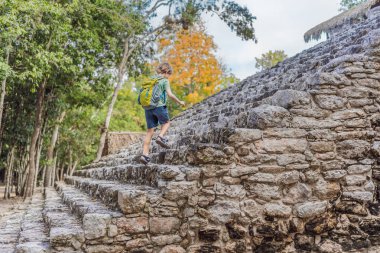Coba, Meksika 'da erkek turist. Meksika 'daki antik Maya şehri. Coba arkeolojik bir alan ve Yucatan Yarımadası 'nın ünlü bir simgesidir. Meksika 'da bir piramidin üzerindeki bulutlu gökyüzü.