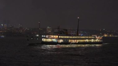 İstanbul Boğazı 'ndan süzülen İstanbul' un büyüleyici ışıkları suda dans ederken, gece feribotu çok güzel aydınlatıyordu.
