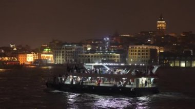 İstanbul Boğazı 'ndan süzülen İstanbul' un büyüleyici ışıkları suda dans ederken, gece feribotu çok güzel aydınlatıyordu.