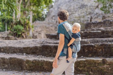 Baba ve oğul turistler Coba, Meksika 'da. Meksika 'daki antik Maya şehri. Coba arkeolojik bir alan ve Yucatan Yarımadası 'nın ünlü bir simgesidir. Meksika 'da bir piramidin üzerindeki bulutlu gökyüzü.