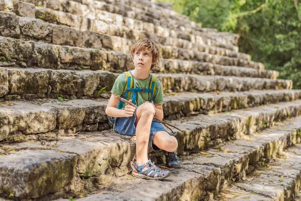 stock image Boy tourist at Coba, Mexico. Ancient mayan city in Mexico. Coba is an archaeological area and a famous landmark of Yucatan Peninsula. Cloudy sky over a pyramid in Mexico.