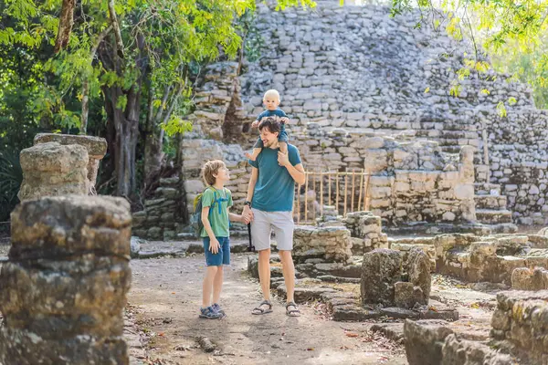 Babam ve iki oğlu Coba, Meksika 'da turist. Meksika 'daki antik Maya şehri. Coba arkeolojik bir alan ve Yucatan Yarımadası 'nın ünlü bir simgesidir. Meksika 'da bir piramidin üzerindeki bulutlu gökyüzü.