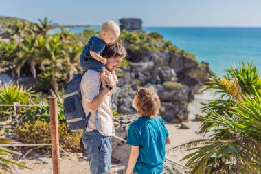 Baba ve iki oğul turist Pre-Columbian Maya duvarlı şehri Tulum, Quintana Roo, Meksika, Kuzey Amerika, Tulum, Meksika 'nın tadını çıkarıyorlar. El Castillo - Şato Maya şehri Tulum ana tapınağı.