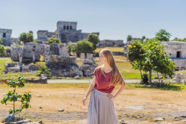 Kolombiya öncesi Maya şehri Tulum, Quintana Roo, Meksika, Kuzey Amerika, Tulum, Meksika manzarasının tadını çıkaran bir kadın turist. El Castillo - Şato Maya şehri Tulum ana tapınağı.