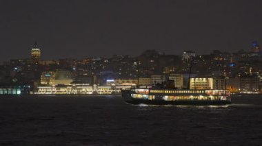 İstanbul Boğazı 'ndan süzülen İstanbul' un büyüleyici ışıkları suda dans ederken, gece feribotu çok güzel aydınlatıyordu.
