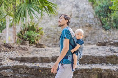 Baba ve oğul turistler Coba, Meksika 'da. Meksika 'daki antik Maya şehri. Coba arkeolojik bir alan ve Yucatan Yarımadası 'nın ünlü bir simgesidir. Meksika 'da bir piramidin üzerindeki bulutlu gökyüzü.