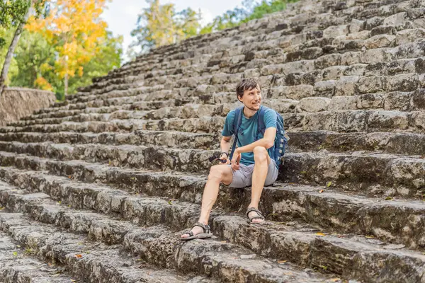 Coba, Meksika 'da erkek turist. Meksika 'daki antik Maya şehri. Coba arkeolojik bir alan ve Yucatan Yarımadası 'nın ünlü bir simgesidir. Meksika 'da bir piramidin üzerindeki bulutlu gökyüzü.