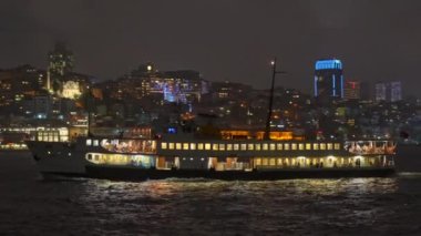 İstanbul Boğazı 'ndan süzülen İstanbul' un büyüleyici ışıkları suda dans ederken, gece feribotu çok güzel aydınlatıyordu.
