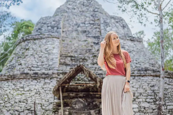 stock image Woman tourist at Coba, Mexico. Ancient mayan city in Mexico. Coba is an archaeological area and a famous landmark of Yucatan Peninsula. Cloudy sky over a pyramid in Mexico.