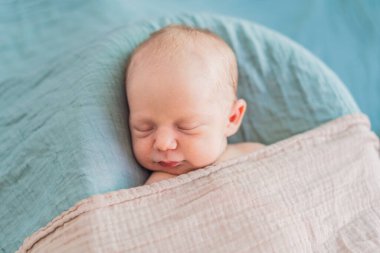 Bebek rahat yuvasında huzur içinde uyuyor. Yeni doğan fotoğraf çekimi, ilk zamanların dingin masumiyetini ve sıcaklığını yakalar..