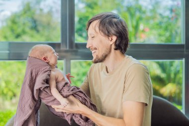 Babam ve yeni doğmuş bebek evde. Bu hassas an, baba ve çocuk arasındaki sevgi dolu ve rahat aile ortamını yakalar. Ebeveynliğin neşesini ve evin sıcaklığını vurgular..