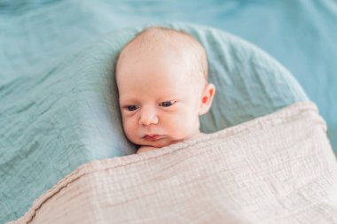 Bebek rahat yuvasında huzur içinde uyuyor. Yeni doğan fotoğraf çekimi, ilk zamanların dingin masumiyetini ve sıcaklığını yakalar..