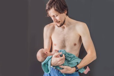 Babam ve yeni doğmuş bebek evde. Bu hassas an, baba ve çocuk arasındaki sevgi dolu ve rahat aile ortamını yakalar. Ebeveynliğin neşesini ve evin sıcaklığını vurgular..