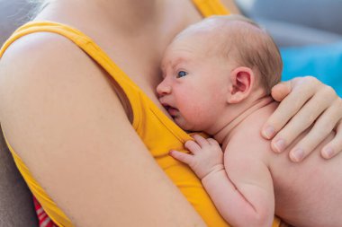 Yeni doğmuş bebeği olan anne evdeki kanepede dinleniyor. Bu hassas an anne ve çocuk arasındaki bağı vurguluyor. Rahat ve sevgi dolu bir aile ortamında..