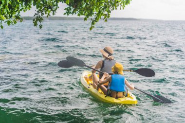 Anne ve oğul turistler Meksika 'daki Bacalar Gölü' nde kano yapıyorlar. Quintana Roo 'da macera turizmi, açık hava keşfi ve su aktiviteleri konsepti.
