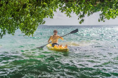 Meksika 'da Bacalar Gölü' nde kayak yapan adam. Quintana Roo 'da macera turizmi, açık hava keşfi ve su aktiviteleri konsepti.