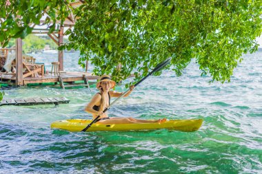 Meksika 'da Bacalar Gölü' nde kayak yapan bir kadın. Quintana Roo 'da macera turizmi, açık hava keşfi ve su aktiviteleri konsepti.