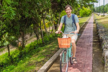 Meksika 'nın büyüleyici Bacalar köyünde bisiklet süren bir adam. Quintana Roo seyahati, manzaralı bisiklet yolları ve çevre dostu keşif konsepti..