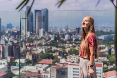 Kadın turist ya da iş kadını, Mexico City manzaralı bir gökdelenin çatısında dikiliyor. Meksika konseptinde seyahat ya da uluslararası iş.