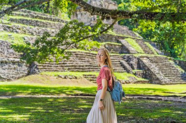 Palenque, Meksika 'nın antik piramitlerini keşfeden kadın turist, sık ormanlarla çevrili. Kültür mirası ve macera yolculuğu konsepti.