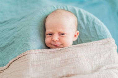 Bebek rahat yuvasında huzur içinde uyuyor. Yeni doğan fotoğraf çekimi, ilk zamanların dingin masumiyetini ve sıcaklığını yakalar..
