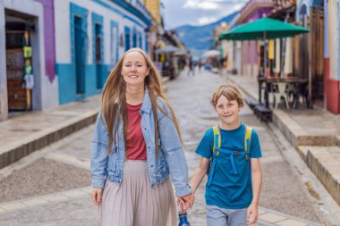 Annesi ve oğlu turistler San Cristobal de las Casas, Meksika 'da koloni sokaklarında yürüyorlar. Kültürel keşif, mimari ve seyahat deneyimi konsepti.