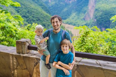 Dad and his two sons baby and teenager travelers exploring Sumidero Canyon National Park, Mexico. Adventure, natural exploration, and travel experience concept. clipart