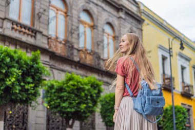 Puebla, Meksika 'nın renkli koloni sokaklarında yürüyen kadın turist. Seyahat, kültürel keşif ve canlı mimari konsepti..