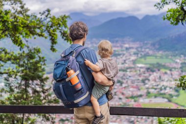 Babası ve küçük oğlu Meksika 'nın Cerro del Borrego kentinden Orizaba' nın panoramik manzarasının önünde turistler. Seyahat, manzara ve macera konsepti..