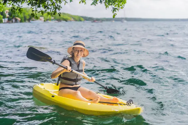 Meksika 'da Bacalar Gölü' nde kayak yapan bir kadın. Quintana Roo 'da macera turizmi, açık hava keşfi ve su aktiviteleri konsepti.