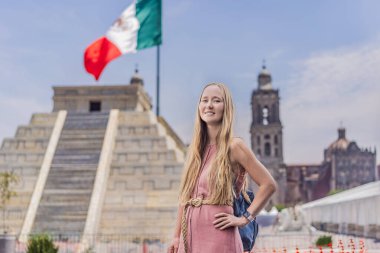 Mexico City 'deki tarihi Zocalo Meydanı' nı keşfeden bir kadın, arka planda Meksika bayrağı sallanan bir Aztek piramidinin önünde duruyor. Metropolitan Katedrali görülebilir.