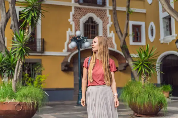 Puebla, Meksika 'nın renkli koloni sokaklarında yürüyen kadın turist. Seyahat, kültürel keşif ve canlı mimari konsepti..
