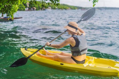 Meksika 'da Bacalar Gölü' nde kayak yapan bir kadın. Quintana Roo 'da macera turizmi, açık hava keşfi ve su aktiviteleri konsepti.