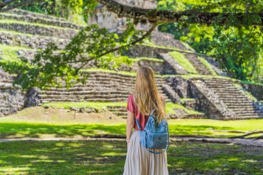 Palenque, Meksika 'nın antik piramitlerini keşfeden kadın turist, sık ormanlarla çevrili. Kültür mirası ve macera yolculuğu konsepti.