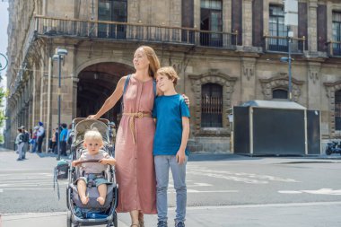 Annesi, küçük oğlu ve genç oğlu Mexico City, Zocalo 'nun merkez meydanında turistler. Aile seyahati, kültürel keşif ve tarihi mimari konsepti..