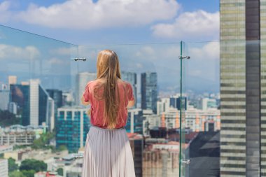Kadın turist ya da iş kadını, Mexico City manzaralı bir gökdelenin çatısında dikiliyor. Meksika konseptinde seyahat ya da uluslararası iş.