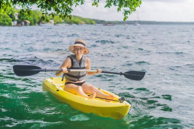 Meksika 'da Bacalar Gölü' nde kayak yapan bir kadın. Quintana Roo 'da macera turizmi, açık hava keşfi ve su aktiviteleri konsepti.
