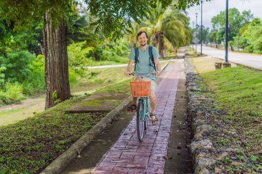 Meksika 'nın büyüleyici Bacalar köyünde bisiklet süren bir adam. Quintana Roo seyahati, manzaralı bisiklet yolları ve çevre dostu keşif konsepti..