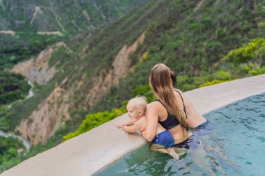 Mother with her toddler and teenage sons bathing in the hot springs of Grutas Tolantongo, Mexico. Family adventure, relaxation, and natural wellness concept. clipart