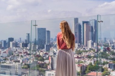 Kadın turist ya da iş kadını, Mexico City manzaralı bir gökdelenin çatısında dikiliyor. Meksika konseptinde seyahat ya da uluslararası iş.