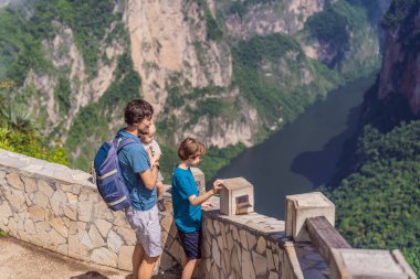 Babam ve iki oğlu bebek ve Sumidero Canyon Ulusal Parkı 'nı keşfeden genç gezginler. Macera, doğal keşif ve seyahat deneyimi konsepti.