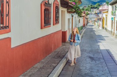 Kadın turist San Cristobal de las Casas, Meksika 'da koloni sokaklarında yürüyor. Kültürel keşif, mimari ve seyahat deneyimi konsepti.