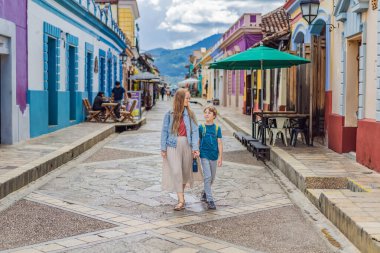 Annesi ve oğlu turistler San Cristobal de las Casas, Meksika 'da koloni sokaklarında yürüyorlar. Kültürel keşif, mimari ve seyahat deneyimi konsepti.