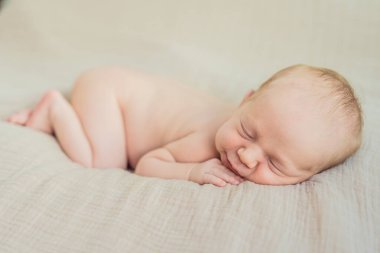 Bebek rahat yuvasında huzur içinde uyuyor. Yeni doğan fotoğraf çekimi, ilk zamanların dingin masumiyetini ve sıcaklığını yakalar..